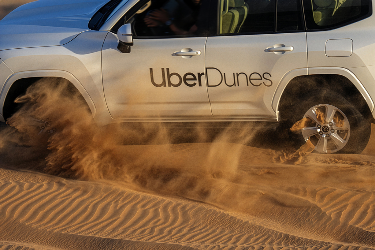 UberDunes Land Cruiser drifting through desert sand, dust flying